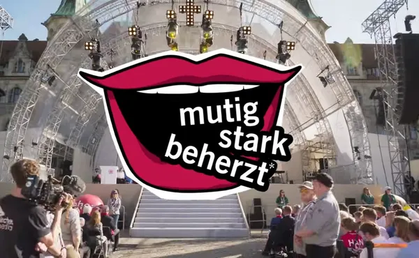 Bühne in Hannover mit dem Logo mutig stark beherzt, ein gif lachender Mund  aus dem die Worte kommen